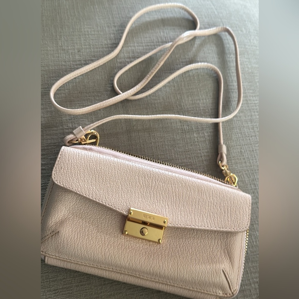 Tumi light pink phone wallet with crossbody strap